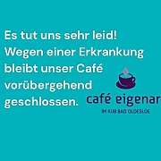 Ein Glas Latte Macchiato auf einem Holztisch in einem Café.