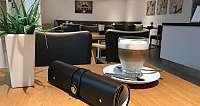 Ein Glas Latte Macchiato auf einem Holztisch in einem Café.